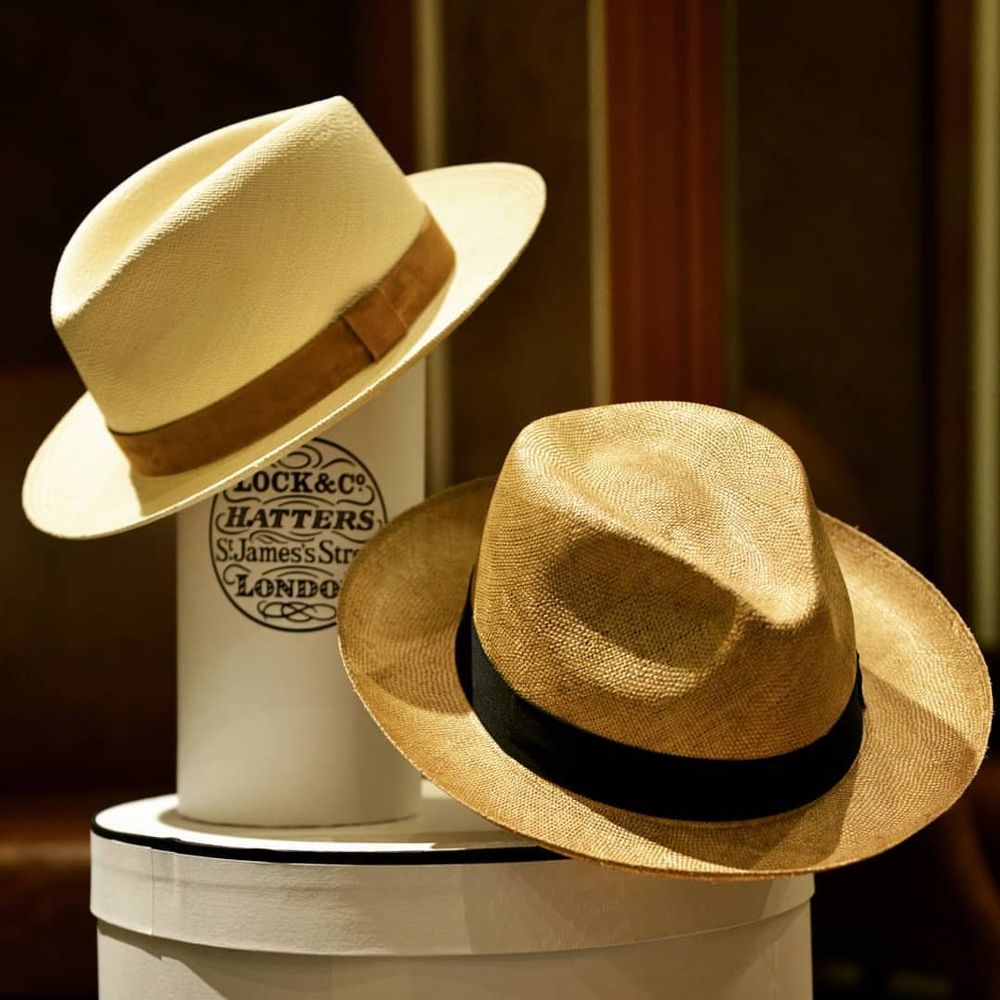 Two straw hats. One is slightly darker and rougher than the other. 