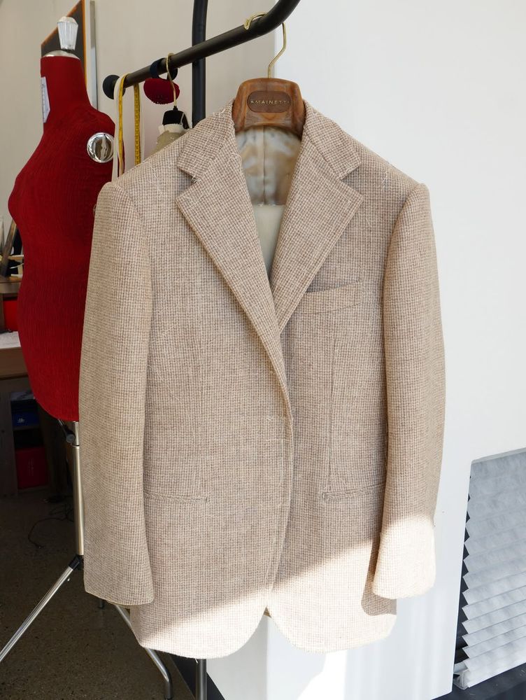 An oatmeal-colored single-breasted tweed sport coat with notch lapels, jetted pockets, and welted out-breast pocket