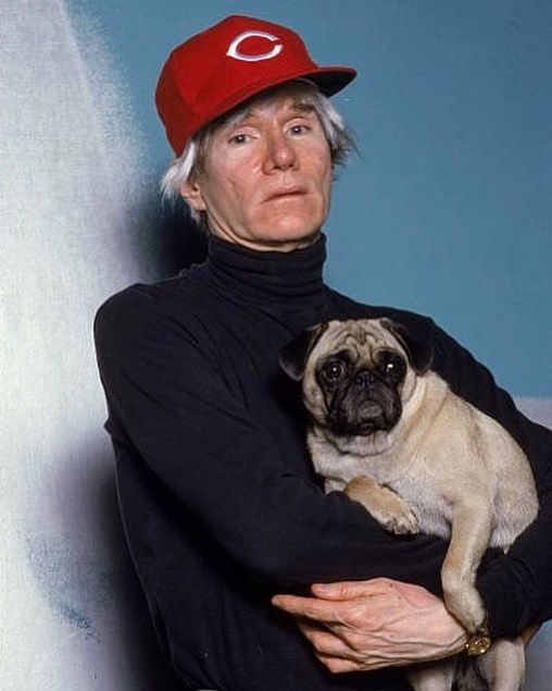 Andy Warhol in a black turtleneck and red Cincinnati hat