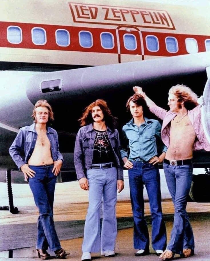 Led Zepplin in low-rise blue jeans. They've styled them with open shirts, chambray Western shirts, and denim jackets. 