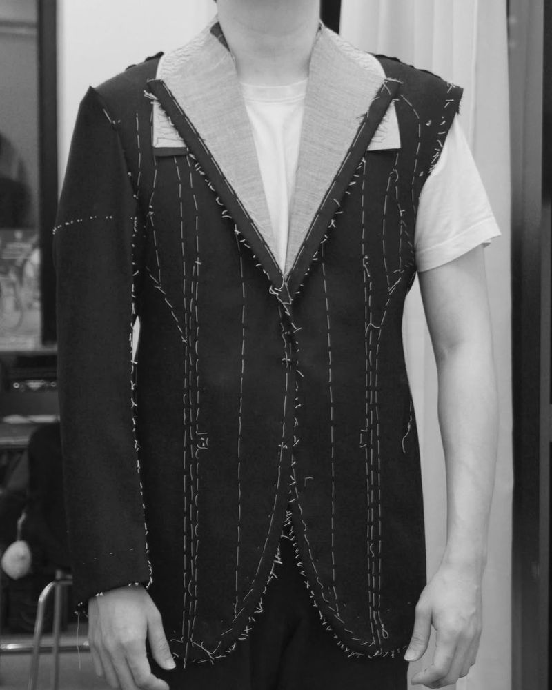 A man at a basted fitting for his suit. 