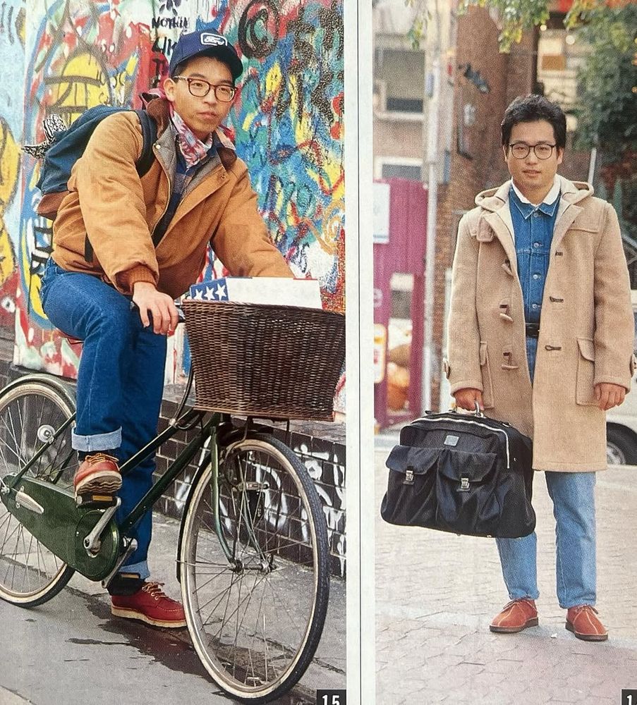 A man wearing a tan jacket with blue jeans. And another man wearing a tan duffle coat over a denim shirt and light blue jeans. 