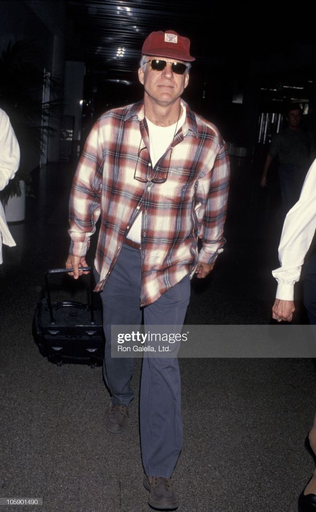 Steve Martin in a red-white flannel, blue chinos, white t-shirt, and red Polo Sportsman cap