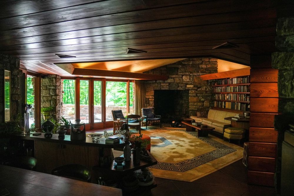 Another living space with a fireplace and bookshelf. Possibly a compression hallway leading to this room. 