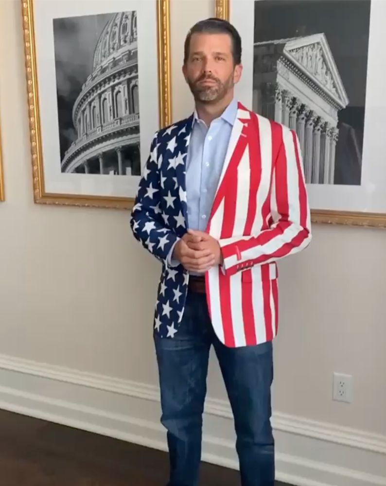 Donald Trump Jr. wearing a USA flag sport coat. The jacket tag has been left on the sleeve.