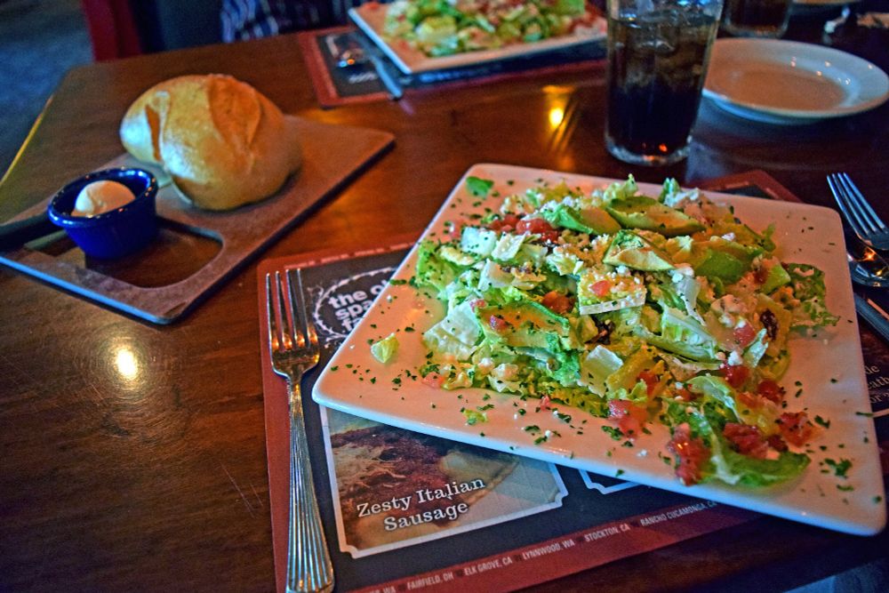Ordering my salad and bun at The Old Spaghetti Factory. The placemat doubles as a menu (neat!) and advertises "Zesty Italian Sausage." 