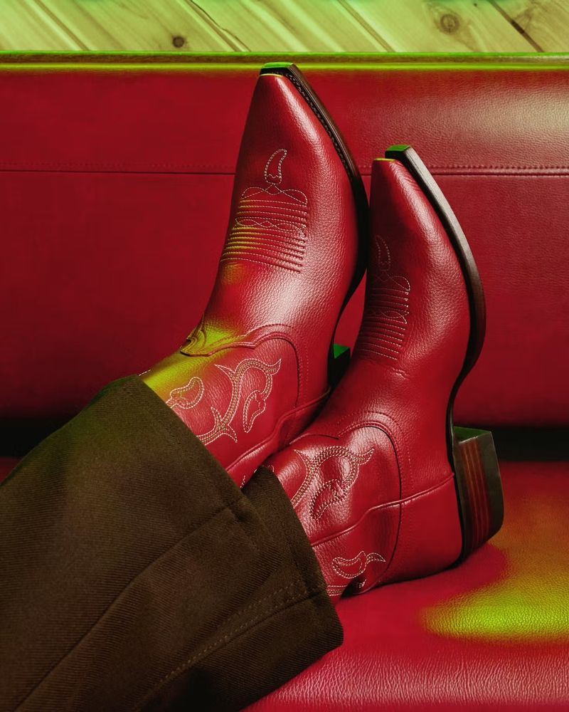Another shot of the guy wearing Chili's cowboy boots. He's paired them with brown pants. 