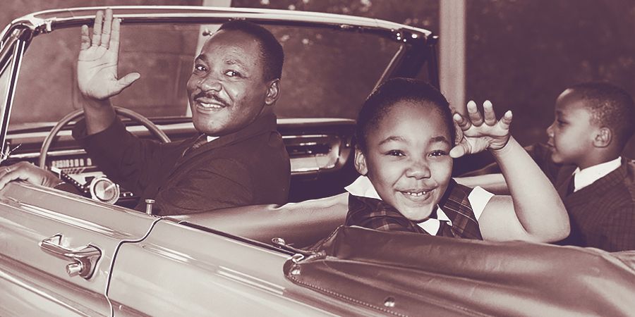 Martin Luther King Jr. and his children waving from their car 