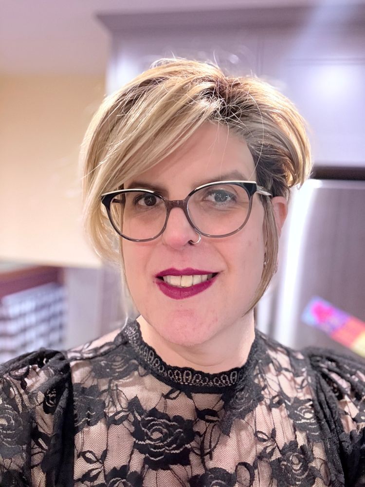 I’m 44 years old in this photo. I’m wearing black floral lace top, my hair is styled in a short asymmetric bob, and I’m legitimately smiling. 