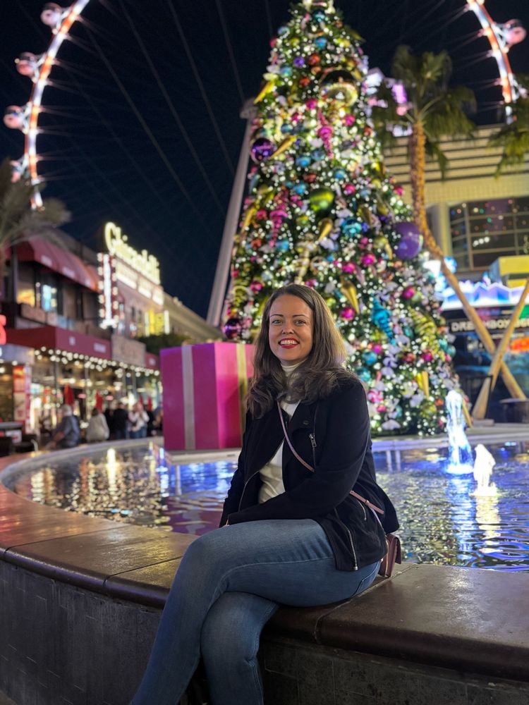 Amanda at a fountain in front of a Christmas tree 