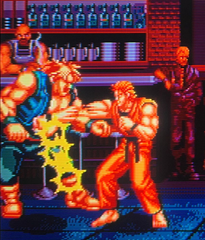 Ryo delivers punch after punch into the midsection of Jack, the bartender looks on with a smoke trail from his cigarette 