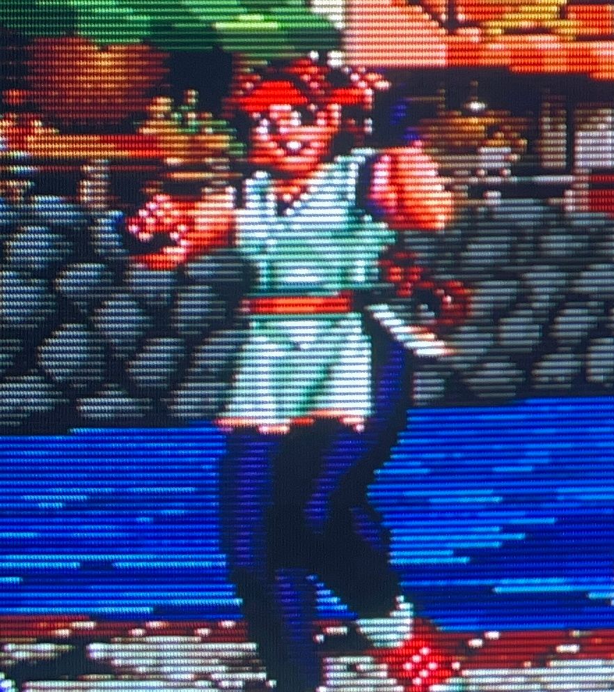 yuri smiles at the screen gleefully. the rocks behind her are stacked high on the other side of the river // The King of Fighters 98 for Neo Geo AES, photography on CRT TV 