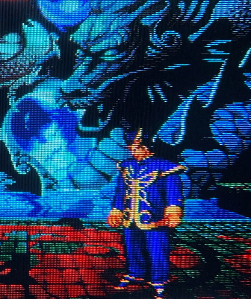Jin Chonrei stares down their opponent on a stage bathed in blue light. A statue of a dragon in the background casts a similarly sinister glare // Real Bout Fatal Fury 2: The Newcomers for Neo Geo AES, photography on CRT TV 