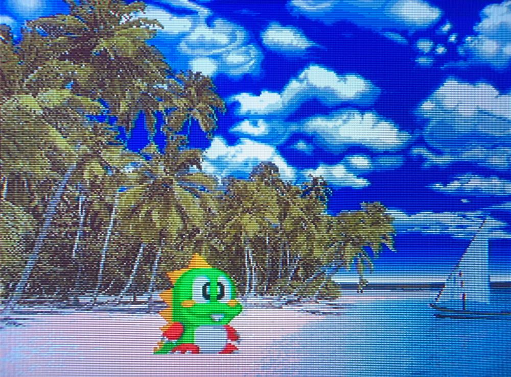 a calm blue beach with a tiny sailboat welcomes Bub the dragon // Puzzle Bobble 2 for Neo Geo AES, photography on CRT TV 