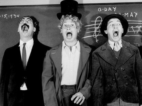 Groucho, Harpo and Chico Marx, singing in front of a blackboard
