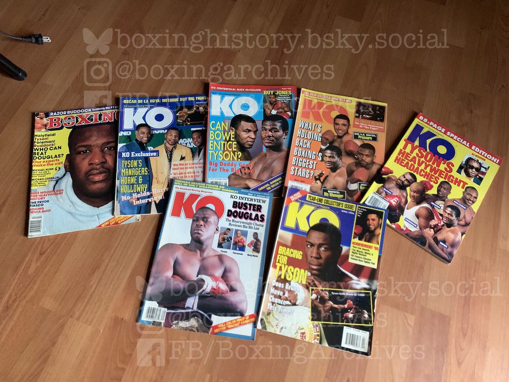 Group of vintage boxing magazines laying flat on a wooden floor.