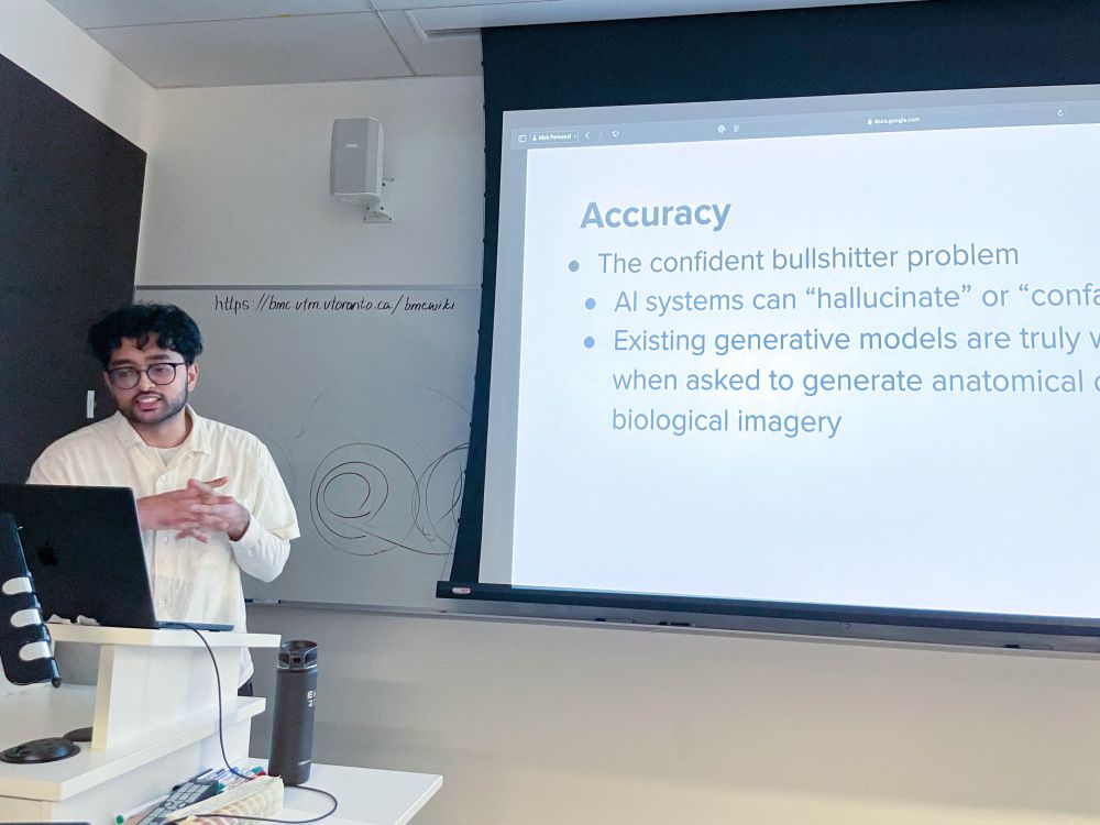 Sesson co-organizer Shay Saharan, who wears glasses and a light-colored shirt, presents in front of a projected slide entitled "Accuracy." The slide lists issues with AI, including "the confident bullshitter problem," AI "hallucinations," and the limitations of generative models in producing accurate anatomical or biological imagery.
