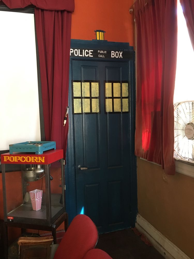 A door painted to look like the Tardis from Doctor Who, nearby is a popcorn machine 