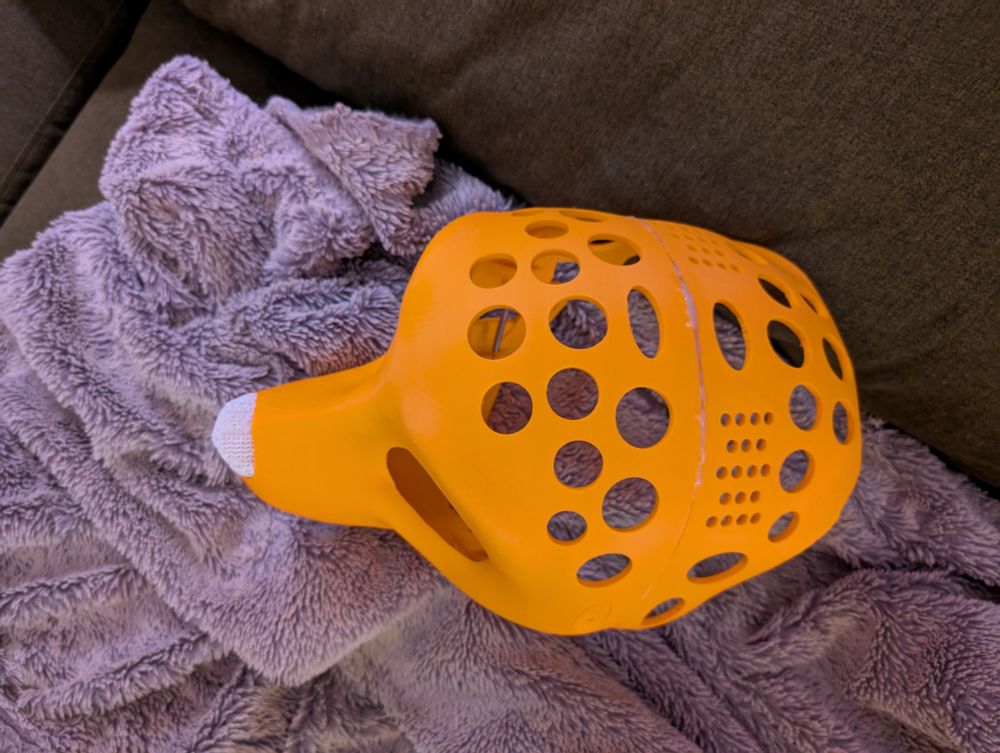 Bright orange 3D printed fursuit head base, with a white TPU nose. The nose is printed with a mesh structure to allow airflow. The back of the head has a second print glued to it that extends over the top of the head 