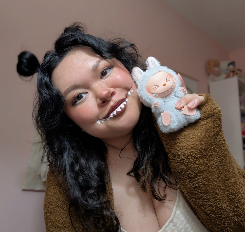 amanda in fake labubu-teeth makeup holding a labubu
