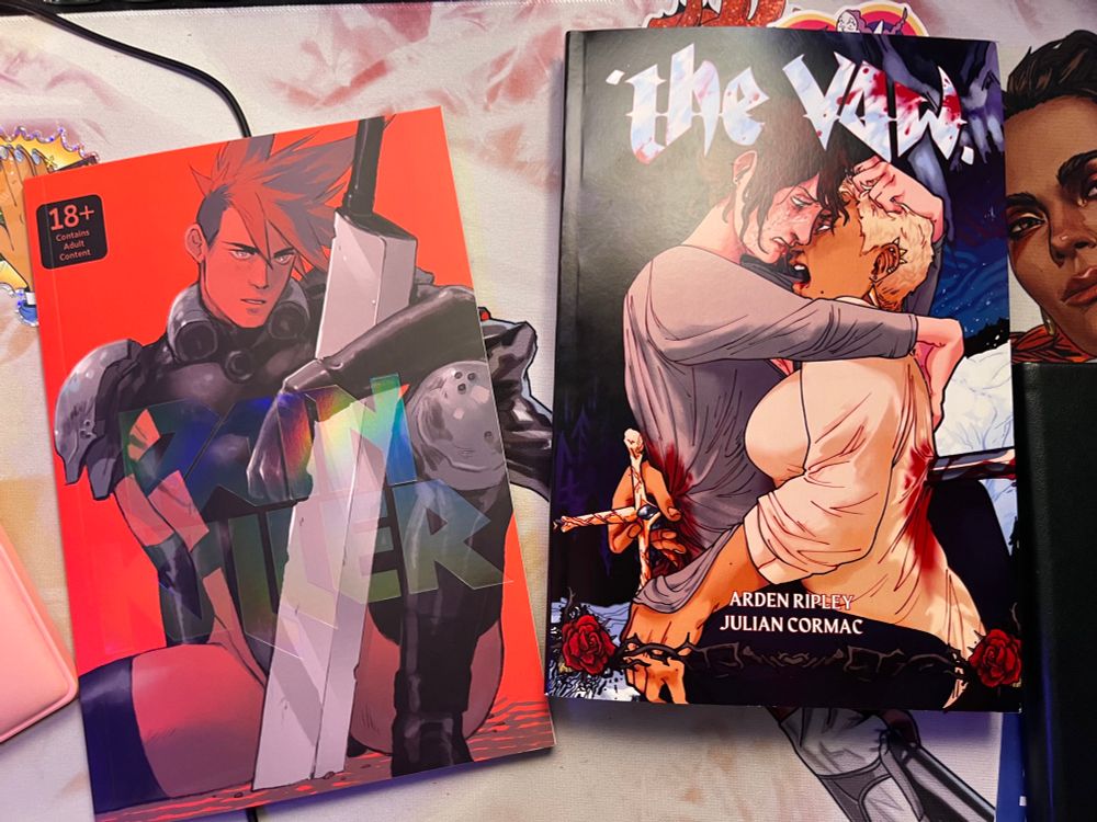 A photo of two queer graphic novels featuring dark themes, on the left is Pain Killer by Hamlet Machine while the right is The Vow by Arden Ripley