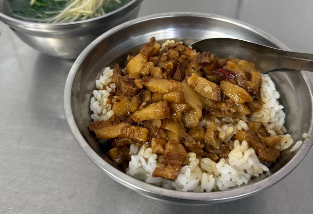 魯肉飯の写真。ホロホロぷりぷりのお肉が美味しそう。後ろにほうれん草の生姜スープもあるよ。銀食器でローカルのお店って感じする。