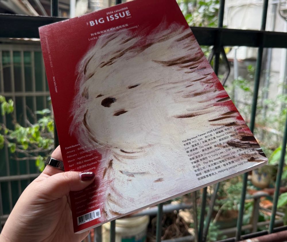 カレンダーの方の裏表紙。風に靡く白いフワフワの犬のイラスト。背景は濃いめの赤。