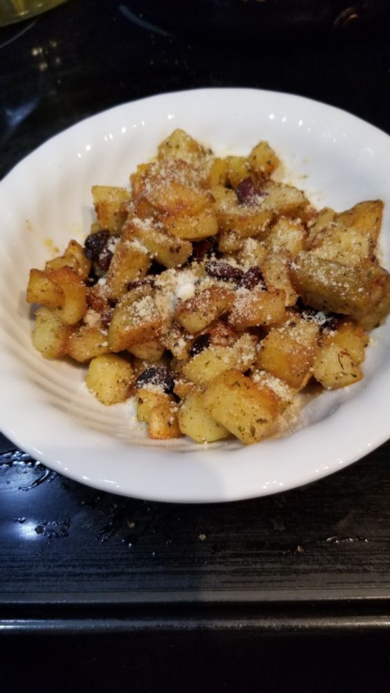 Hashed brown potatoes topped with parmesan in a white bowl 
