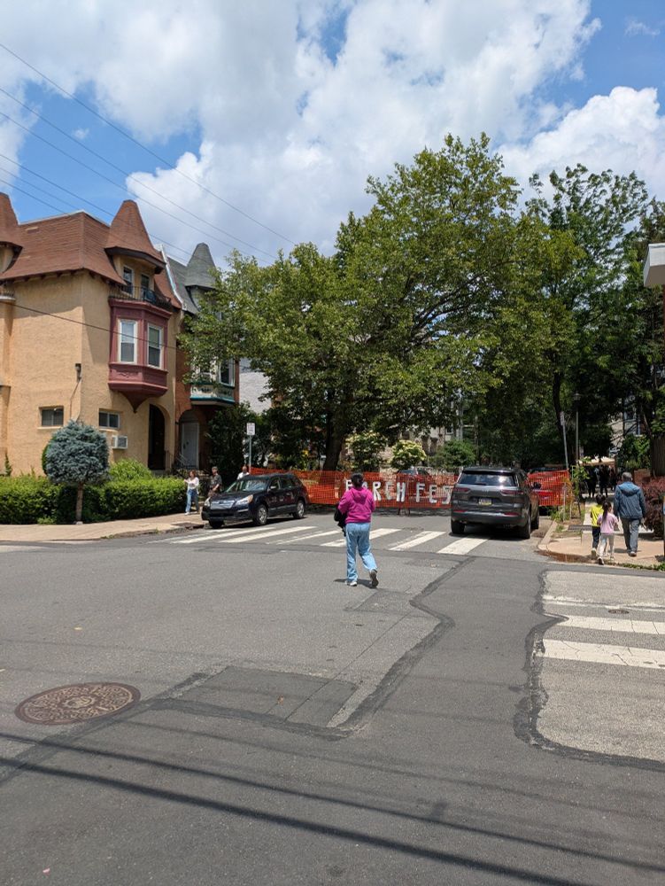 An intersection where the vehicle lanes on one street are blocked off with orange netting that has porch fest in white letters on it