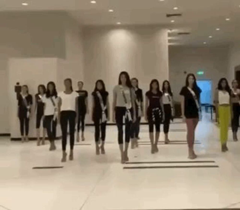 a group of women are standing in a room and dancing .