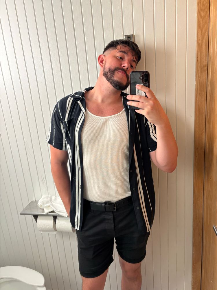 Me posing in front of a wall mirror in a club bathroom