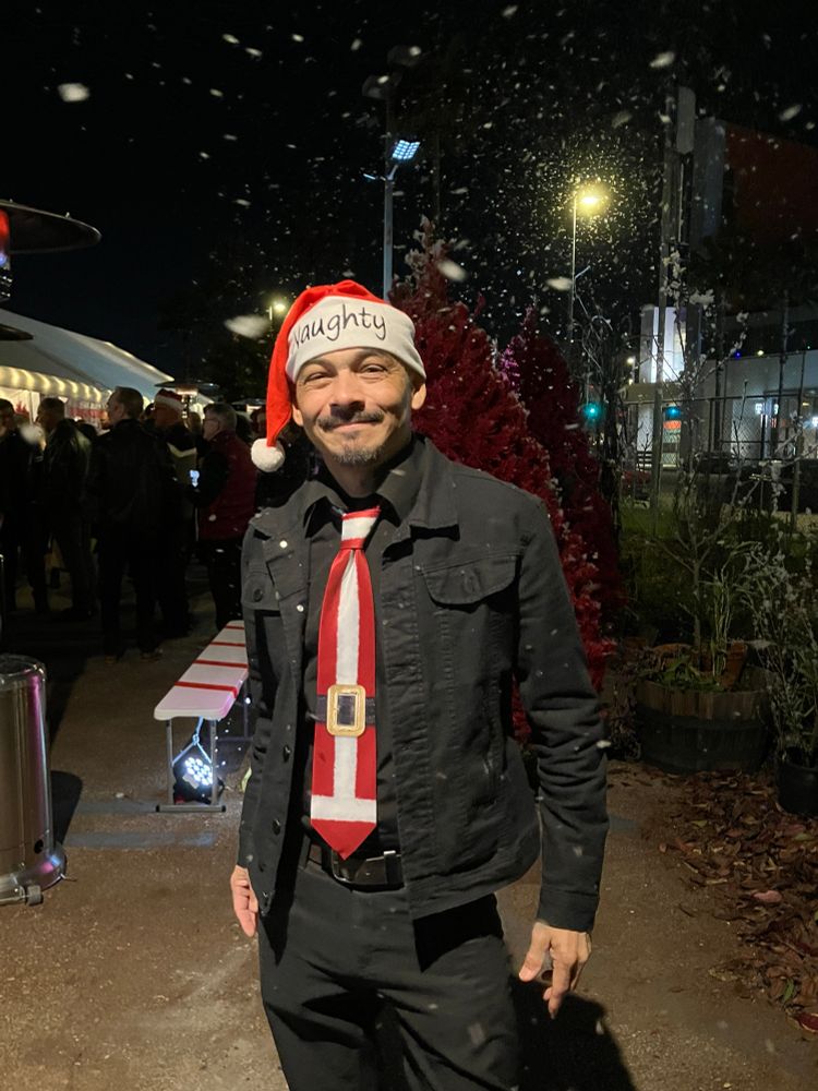 Armando Munoz standing outside in the snowfall at the Silent Night, Deadly Night afterparty.