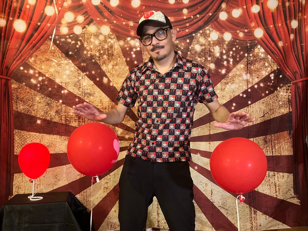 DJ Pervula with many red balloons in a circus.