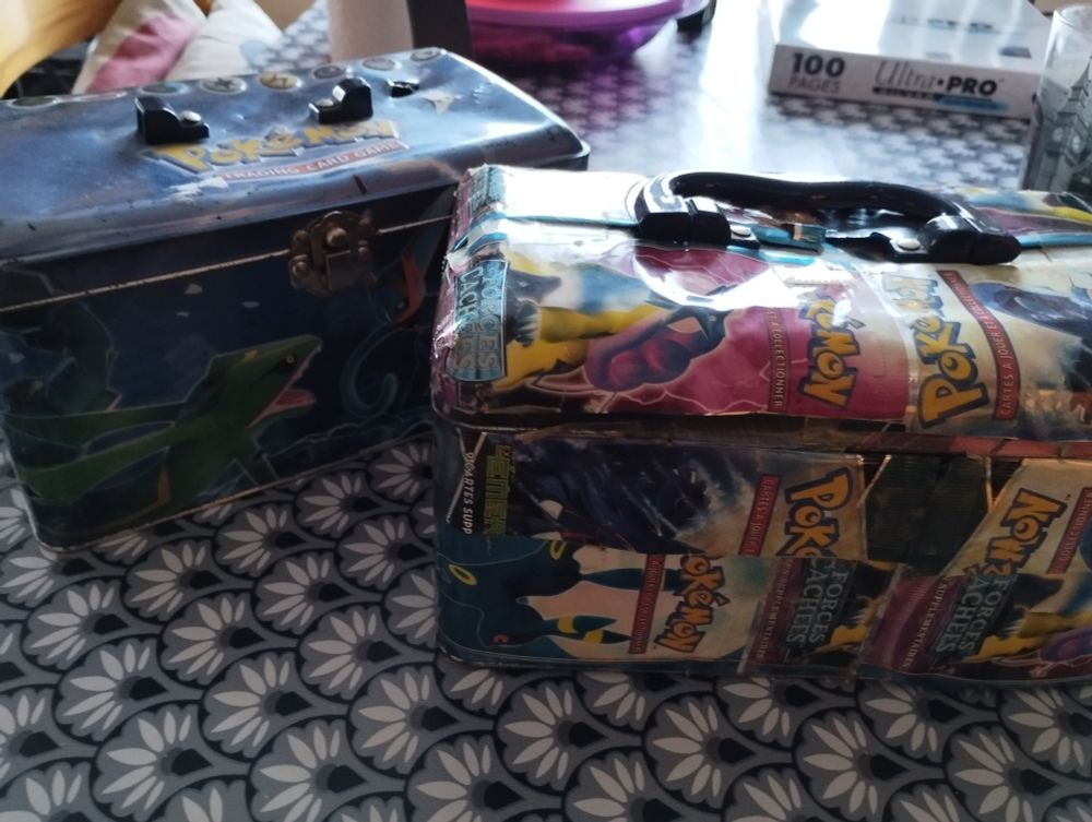 Boîtes pokémon des années 2000 en métal, fermées, et parfois décorées avec des emballages de boosters scotchés