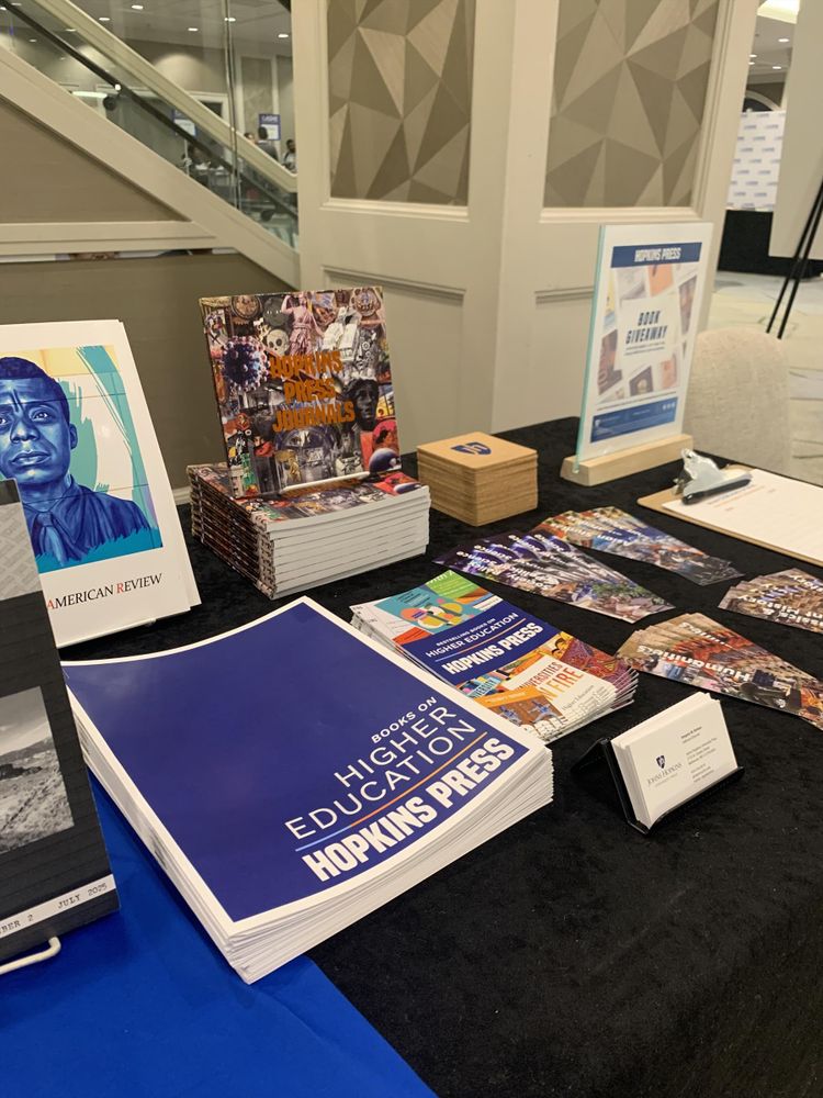 A detail of the journals and giveaways section of the Hopkins Press table at ASHE 2025