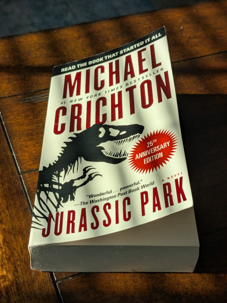 Photo of a paperback copy of Jurassic Park sitting on a coffee table 