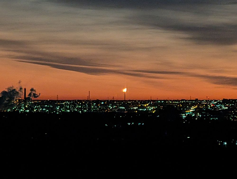 a photograph of the Edmonton skyline at dawn, with a prominent gas flare