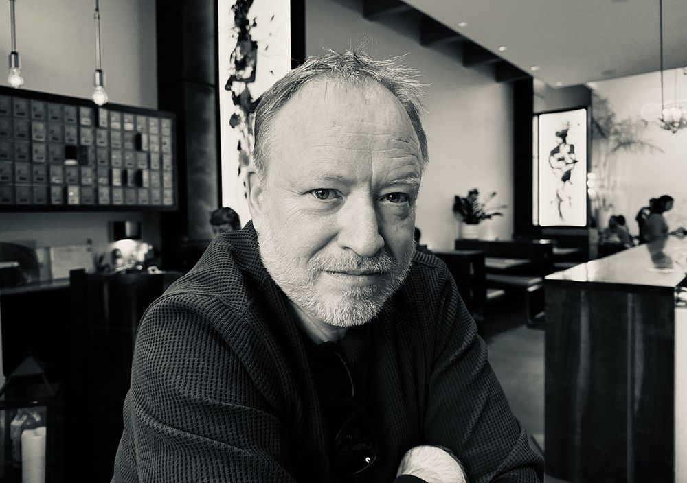 A black and white photograph of a brilliant renaissance man, and all around good human being, James Duncan Davidson looking into the camera.