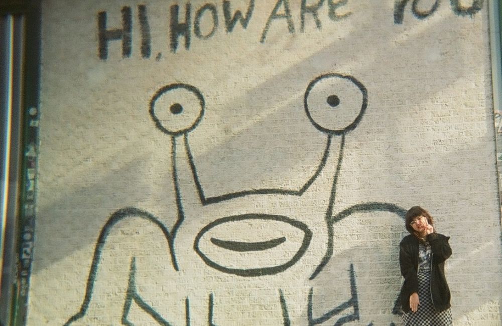 me standing in front of the daniel johnston "hi how are you?" jeremiah the innocent mural in austin, texas