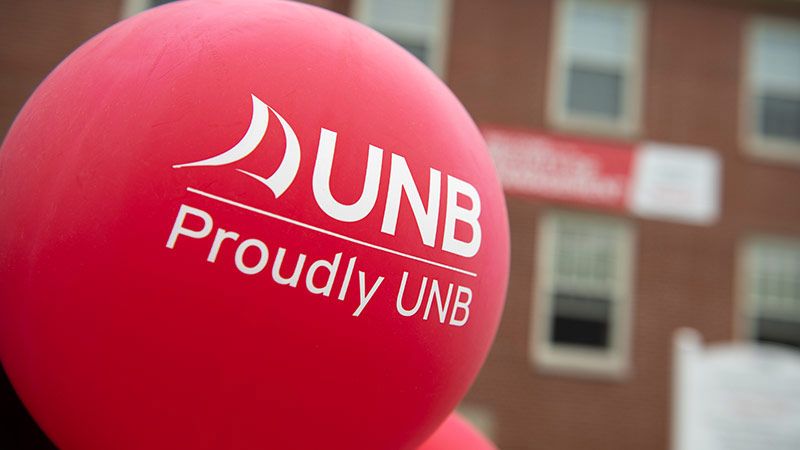 A large red balloon featuring the University of New Brunswick logo and the text Proudly UNB.