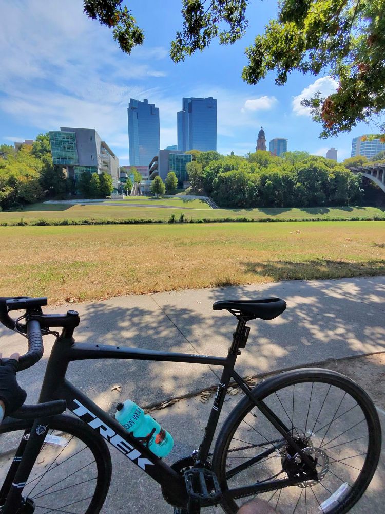 a black trek bike in front of the city skyscape. 