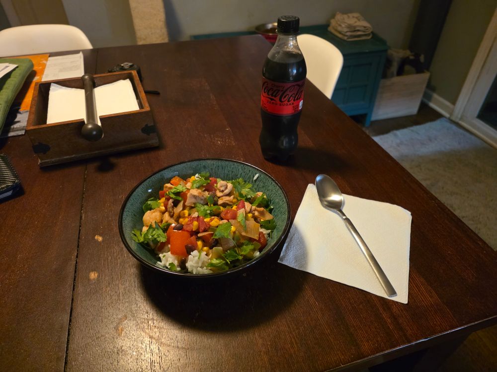 Spicy jalepeño chicken over rice with a bottle of Cherry Coke Zero Sugar.
