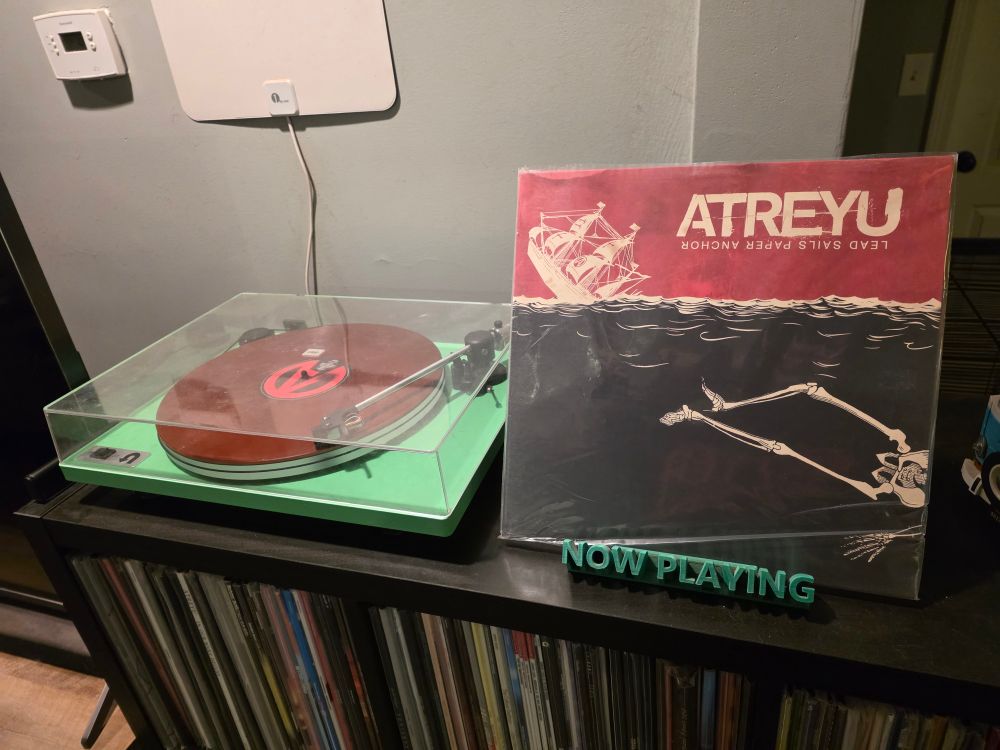 The album "Lead Sails Paper Anchor" by Atreyu plays on a green turntable. 