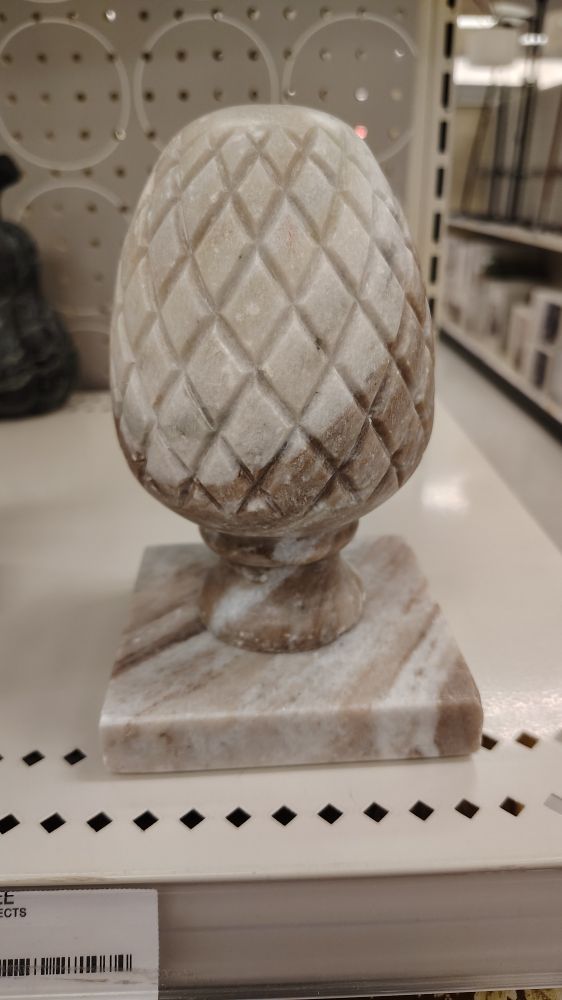 A marble paperweight with a square base, pineapple-like cross-hatch, oval shaped.  Reminiscent of a butt plug.