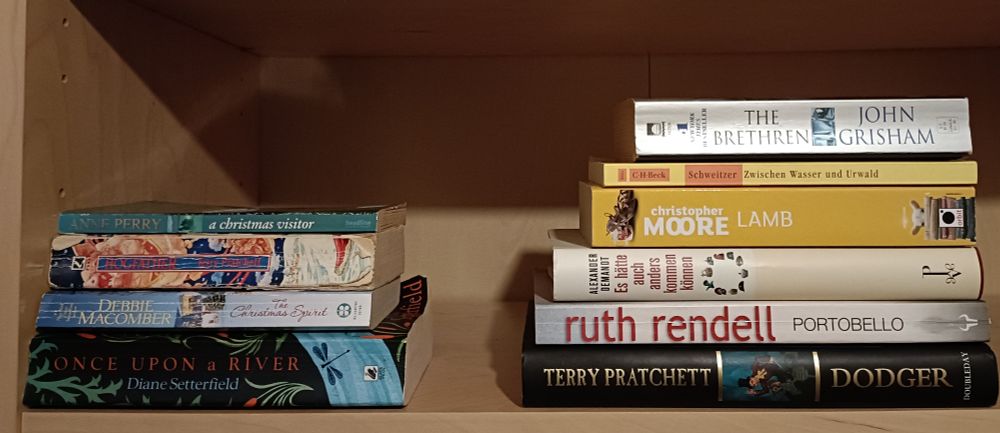 Linker Bücherstapel: 
A Christmas Visitor von Anne Perry
Hogfather von Terry Pratchett 
The Christmas Spirit von Debbie Macomber
Once upon a river von Diane Setterfield

Rechter Bücherstapel: 
The Brethren von John Grisham
Zwischen Wasser und Urwaldvon Albert Schweitzer 
Lamb von Christopher Moore 
Es hätte auch anders kommen können von Alexander Demandt 
Portobello von Ruth Rendell
Dodger von Terry Pratchett 
