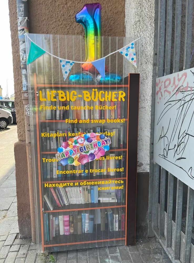 Ein Bücherschrank (Liebig-Bücher) mit Geburtsdeko