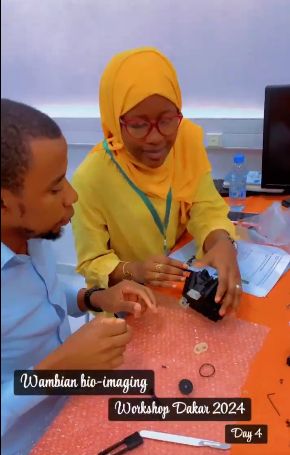 Assembly photo of an OpenFlexure Microscope (video screenshot) from a Wambian bio-imaging workshop in Dakar.