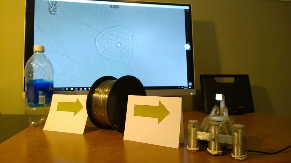 A photo showing a water bottle, 3D printer filament made from water bottles, and a digital microscope made from this filament.