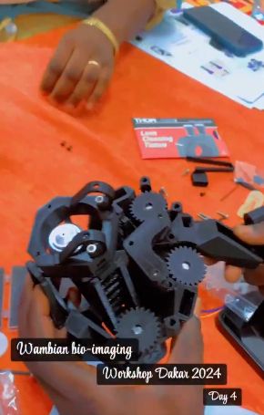 Assembly photo of an OpenFlexure Microscope (video screenshot) from a Wambian bio-imaging workshop in Dakar.