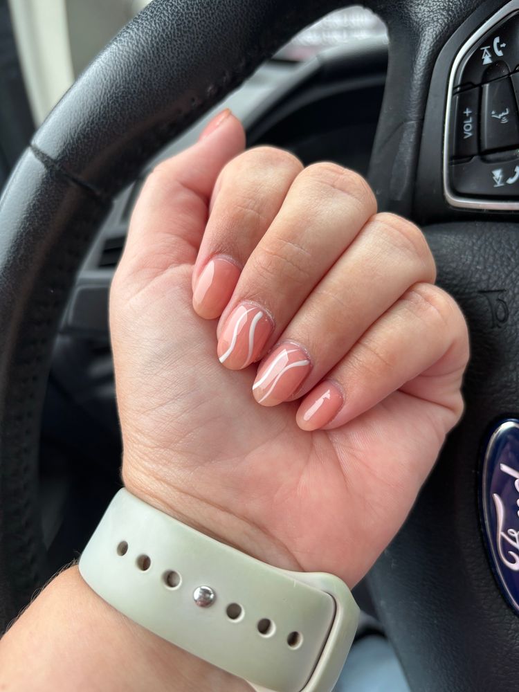 Hand band to show off nails that are orangey pink with two white lines on the middle and ring finger 